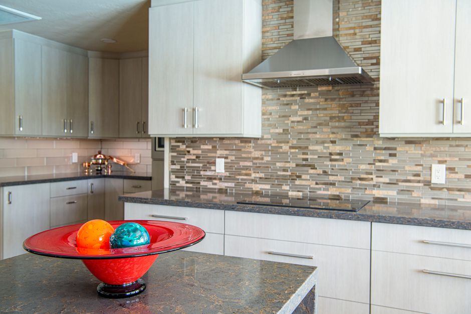 Kitchen countertop with a decorative bowl and cabinets behind.